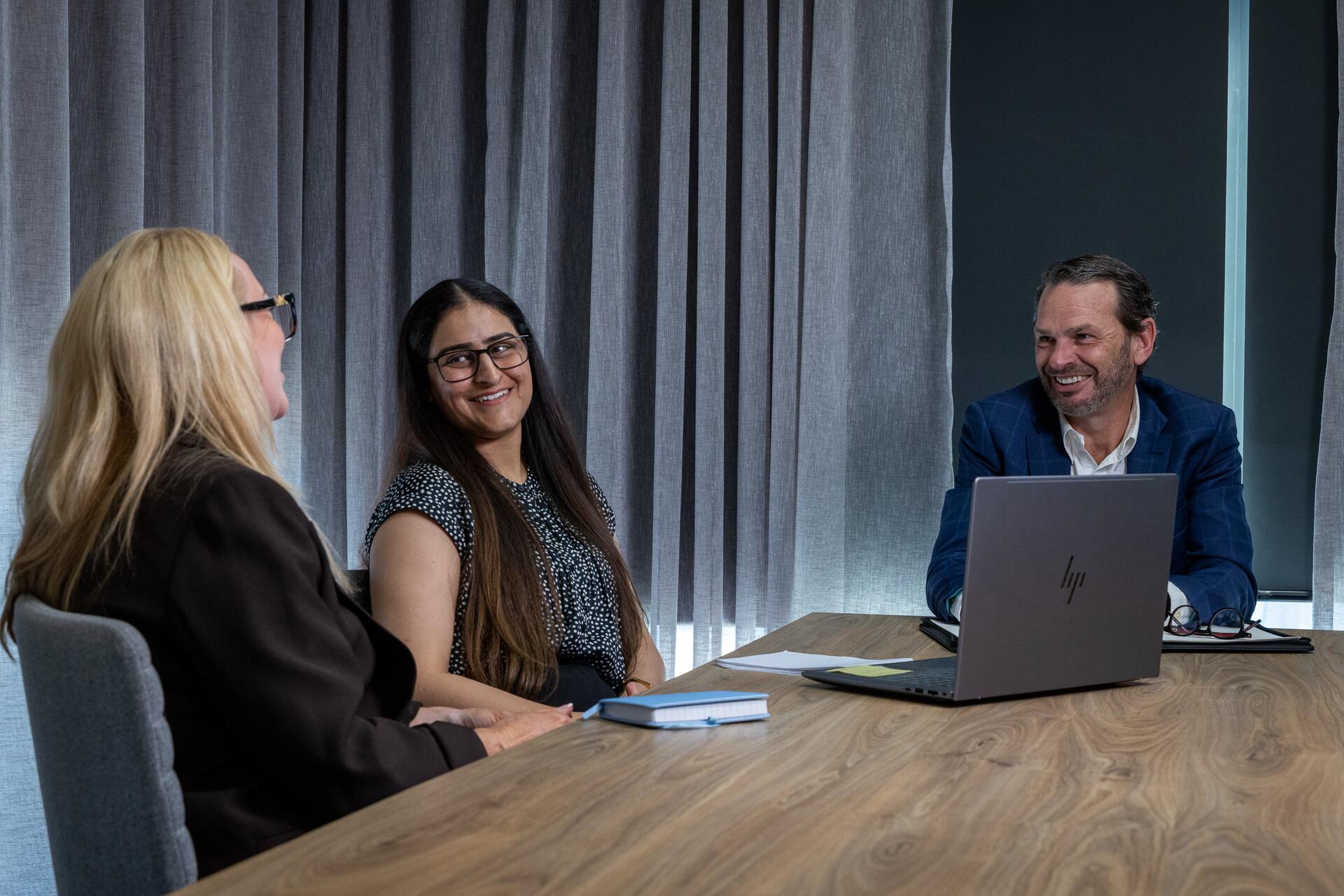 Cameron from Sparrow Advisory meeting with two clients around a boardroom table in the Brisbane office